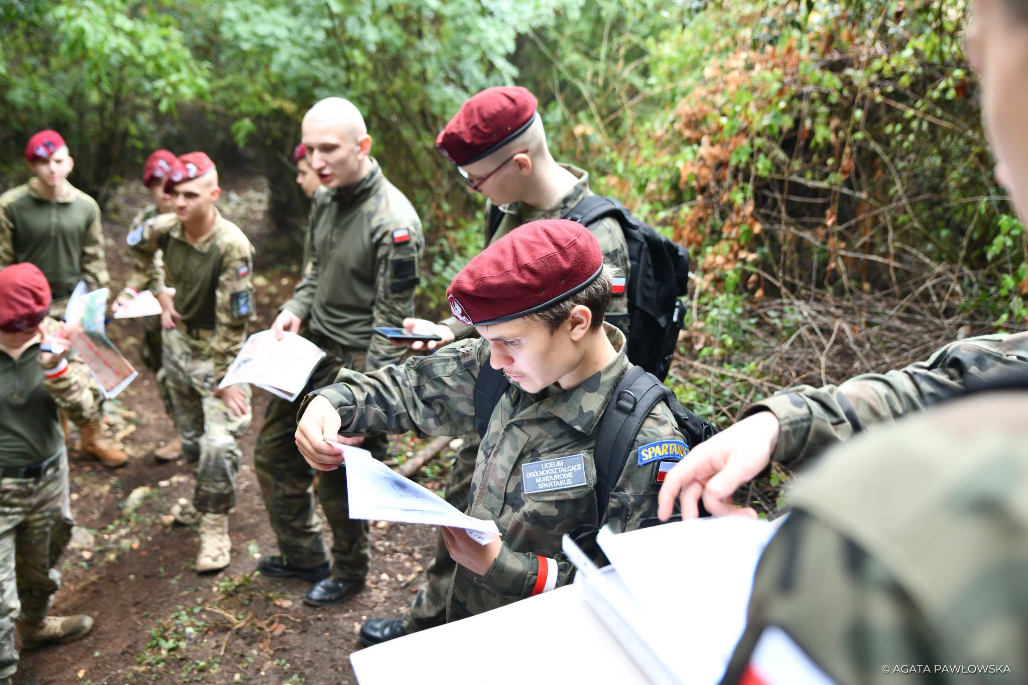 Patrol mundurowy analizujący mapę podczas gry terenowej